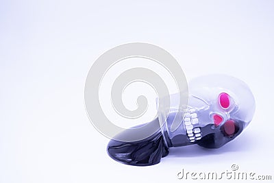 Black mucus flows out of the plastic packaging in the form of a skull with red eyes on a white background. The concept of Stock Photo