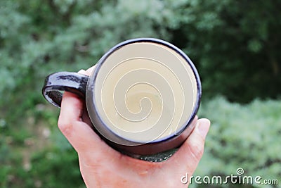 Black mug made of clay. decor - covering with black engobe and transparent glaze. two firing. made on a potter`s wheel. handmade Stock Photo