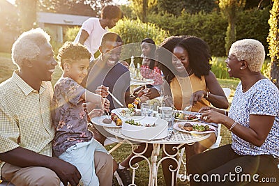 Black multi generation family eating at a table in garden Stock Photo