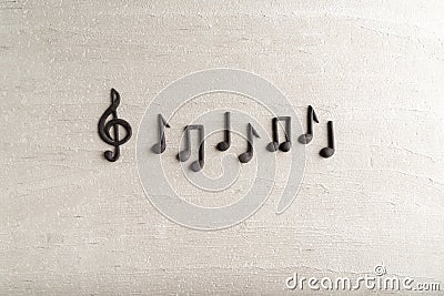 Black music violin clef sign and note on rough beige surface. G-clef. Treble clef. Space for text Stock Photo