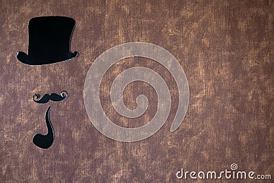 Black mustache and hat on brown leather background texture with copy space, International Men's day and Fathers Day concept Stock Photo