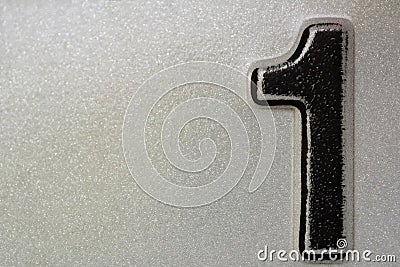 Black number one spray on white reflective metal surface Stock Photo