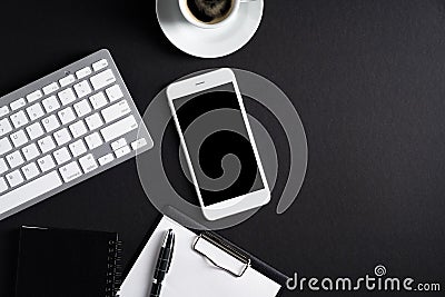 Black office desk table top view. Flat lay smartphone with blank screen mockup, pc keyboard, cup of coffee, clipboard, pen, Editorial Stock Photo