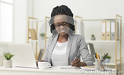 Black Office Girl Sitting At Laptop Taking Notes At Work Stock Photo