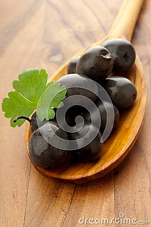 Black olive over wood spoon Stock Photo