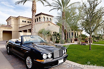 Black open roof car parked outside mansion house Stock Photo