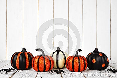 Black and orange glittery Halloween pumpkins against white wood Stock Photo