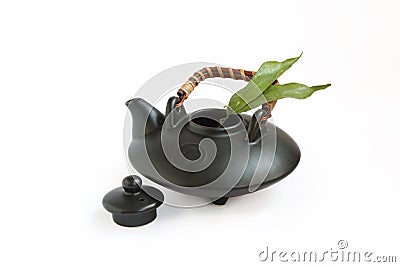Black oriental teapot and tea leaves Stock Photo