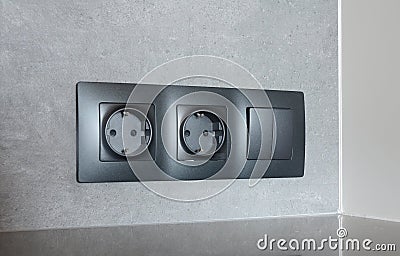 Black outlet plug on the modern kitchen wall. Socket and european power. Stock Photo