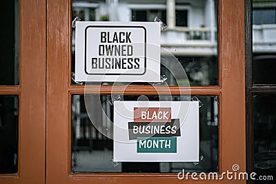Black owned business and black business month sign were attached on the window Stock Photo
