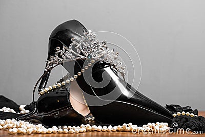 Black patent leather women`s shoes, pearls and diadem on the table Stock Photo