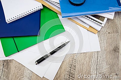 Black pen, colored folders for documents, envelopes, notebooks, stationery on the background of the desktop. View from above. Stock Photo