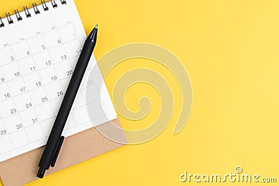Black pen on desktop calendar in flat lay or top view on yellow background with copy space using as writing plan, circle on Stock Photo