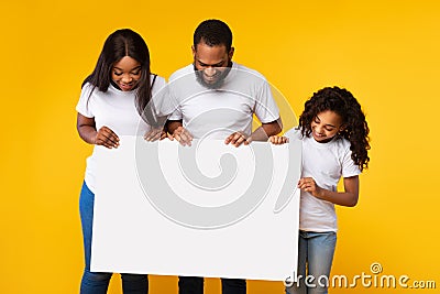 Black people holding blank white advertising billboard at yellow studio Stock Photo