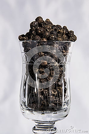 Black pepper in glass with white background Stock Photo