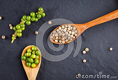 Black pepper spice peppercorn on wooden spoon and dark rustic background Stock Photo