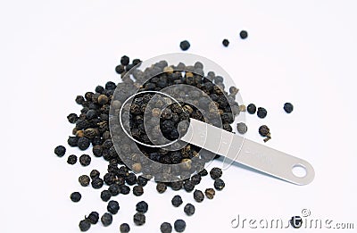 Black peppers in teaspoon on white background Stock Photo