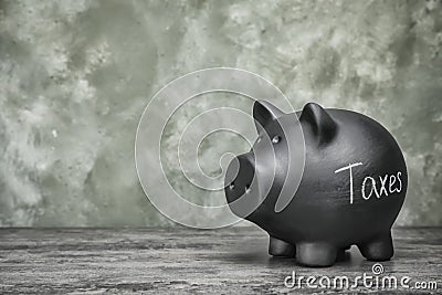 Black piggy bank with word TAXES Stock Photo