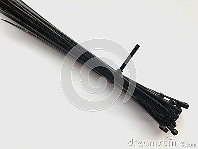 Black plastic cable ties. Plastic clamps on a white background. Industrial Stock Photo