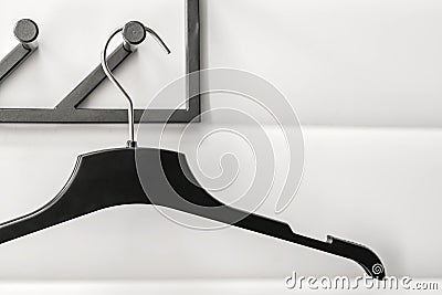 Black plastic hanger on white wall background Stock Photo