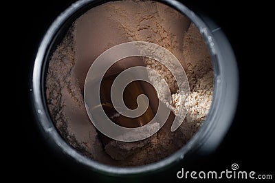 Black plastic jar with a sports supplement protein. On a black background Stock Photo