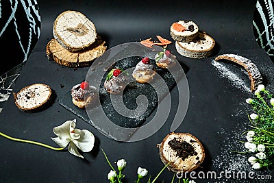 Black Plate With Pastries and Flowers Stock Photo