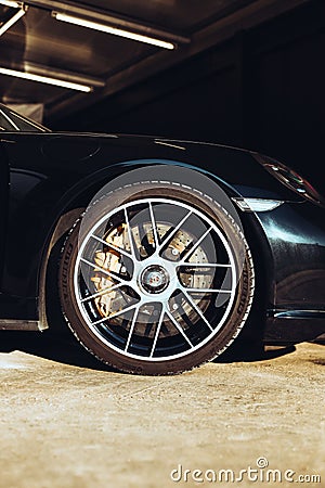 a black porsche sports car with large wheels and polished steel rims Editorial Stock Photo