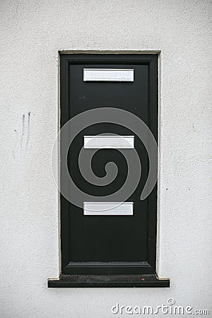 Black postbox in a white wall Stock Photo