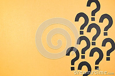 Black question marks on yellow cardboard Stock Photo