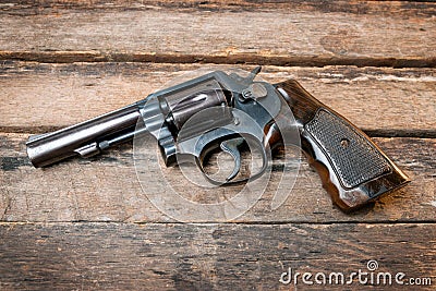 Black revolver gun with bullets isolated on wooden background Stock Photo