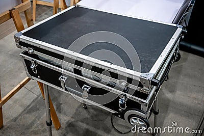 Black road case or flight case with wheels on metal stand for di Stock Photo