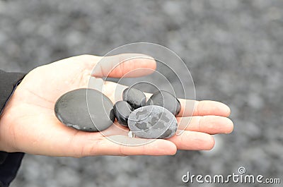 Black rocks on hand from black sand beach Reynisfjara Vik, Iceland Stock Photo