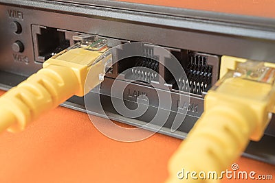 Black router in which yellow patch cords are inserted Stock Photo