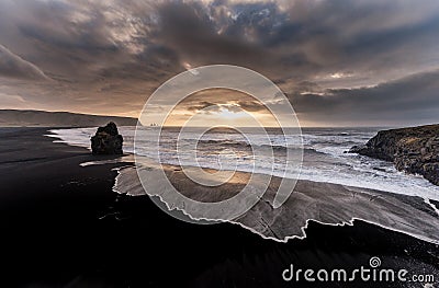 Black Sand Beach Reynisfjara in Iceland. Windy Morning. Ocean Waves. Colorful Sky. Morning Sunset. Stock Photo