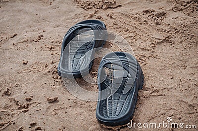 Black sandals on the beach sand Stock Photo