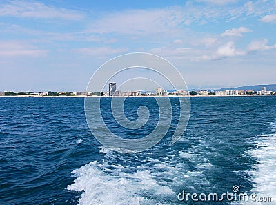 Black sea surface summer wave background. View from yacht. Exotic seascape with clouds and town on horizon. Sea nature tranquility Stock Photo