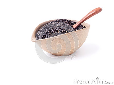 Black sesame in oval light brown bowl and wooden spoon Stock Photo