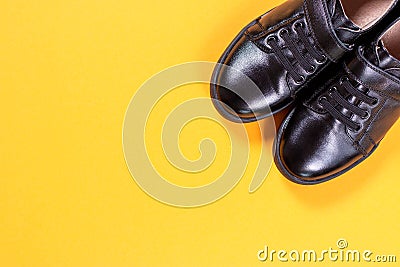 Black shoes on yellow background. Flat lay, top view trendy background. Top view. Copy space Stock Photo