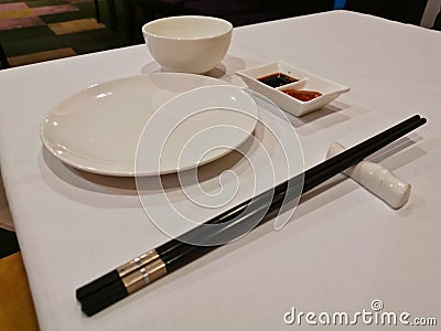 Black shopsticks and white Chinese eating utensil eating equipments in Yum Cha restaurant Stock Photo