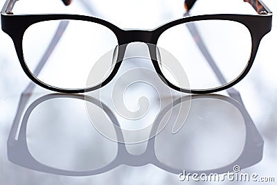 Black shortsighted or nearsighted eyeglasses on white acrylic table background, Close up & Macro shot, Reflection, Optical concept Stock Photo