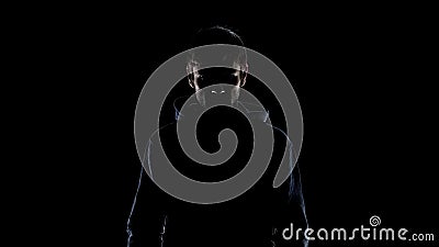 Black silhouette of mysterious man wearing hood, intention to commit crime Stock Photo
