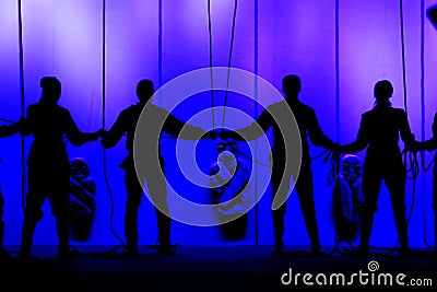 Black silhouettes of people holding hands on the stage of the theater in front of the ropes Editorial Stock Photo