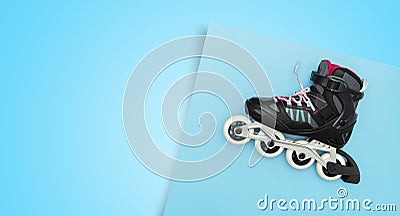 Black single row roller skates on a blue background. Stylish roller skates on blue background, top view Stock Photo