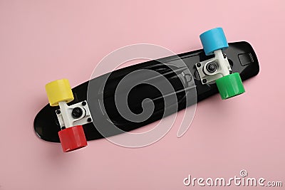 Black skateboard on pink background, top view Stock Photo