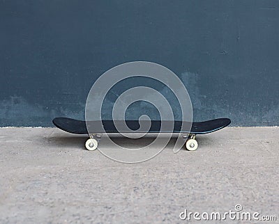 Black skateboard on the street over textured urban background Stock Photo