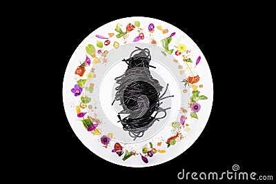 Black squid spaghetti in plate with flower decoration on black background Stock Photo