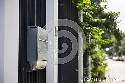 A black steel modern home fence with a plastic door bell and aluminium mail box. Stock Photo