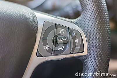 Black steering wheel in the car interior with multifunctional buttons for quick multimedia control. Stock Photo