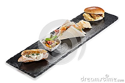 Black stone rectangular tray with snack Pretzel turkey flaky cheese sandwiches salmon pearl spelled vegetables milk sandwiches Stock Photo