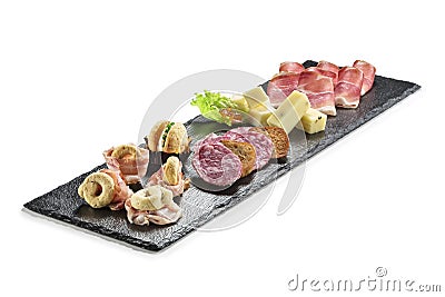 Black stone rectangular tray with snacks speck bacon salami taralli salted macaron cheese with jam Stock Photo